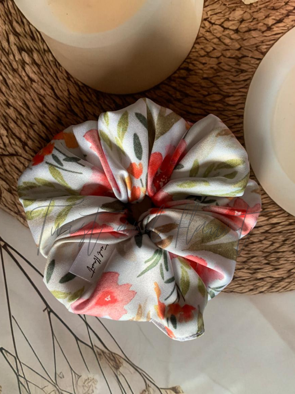 Twist and Flaunt - Floral patterned scrunchie on a textured surface