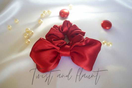 Red satin scrunchie with decorative elements on a light background