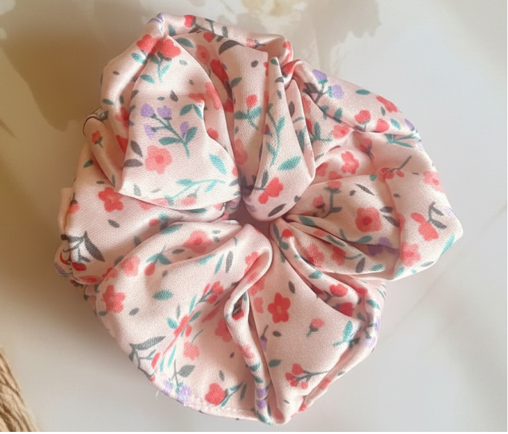 Floral patterned scrunchie on a textured surface with floral elements