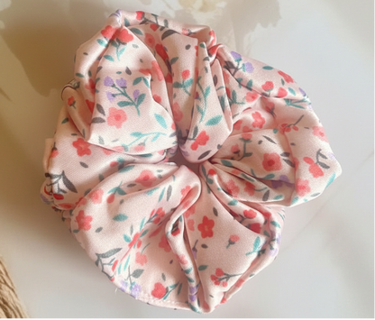 Floral patterned scrunchie on a textured surface with floral elements